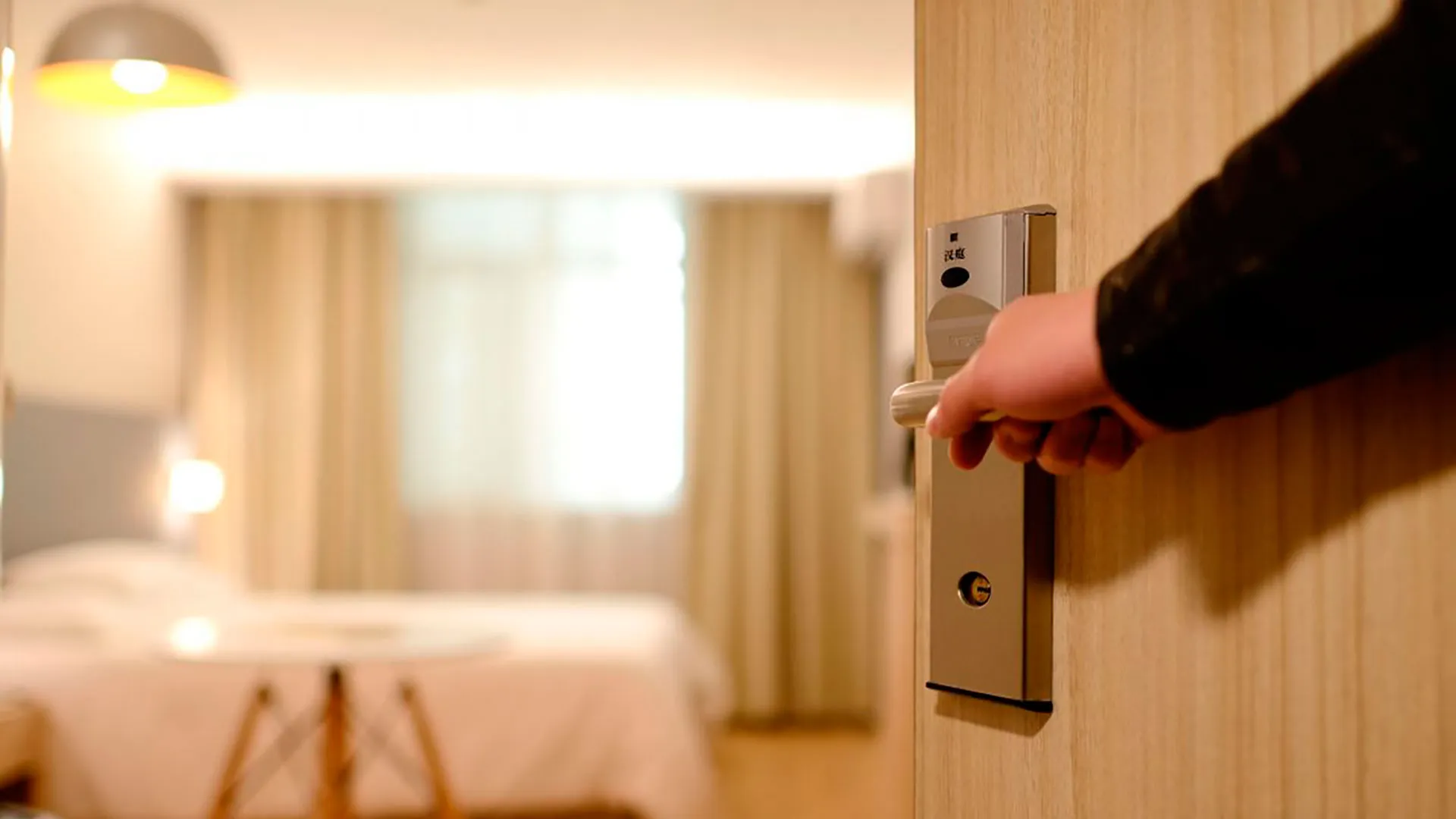Cerradura inteligente en puerta de hotel con apertura por app móvil y tarjeta RFID
